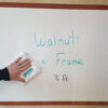 dry erase stick-on surface with faux walnut frame; easy to clean